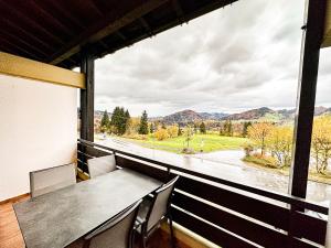 a dining room with a table and chairs and a large window at Bergzauber in Oberstaufen