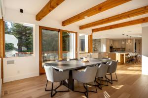 een keuken en eetkamer met een tafel en stoelen bij Peak2Peak Chalet - Stunning Log Chalet w/ Mountain Views & Hot Tub - Whistler Platinum in Whistler