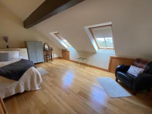 a bedroom with a bed and a chair in a room at Clara Cottage in Eyam