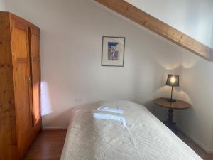 a white bedroom with a bed and a table at Apartment Obstplatz - Free Parking included in Bolzano