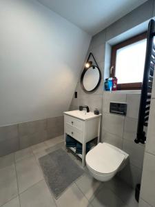 a bathroom with a toilet and a sink and a mirror at Ostoya Twoya in Poronin