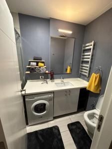 a bathroom with a sink and a washing machine at Kartal Lüks Daire in Istanbul