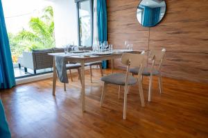 a dining room with a table with chairs and a mirror at Villa Ocean Vista by Swarga Mauritius in Pereybere