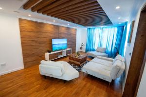 sala de estar con muebles blancos y TV de pantalla plana en Villa Ocean Vista by Swarga Mauritius en Pereybere