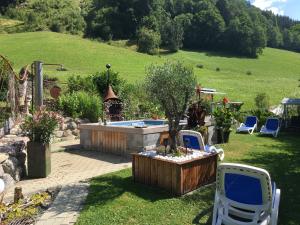 une cour avec une piscine, un arbre et des chaises dans l'établissement Haus Älpele, à Klösterle am Arlberg