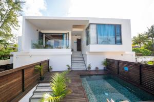 a house with a swimming pool in front of it at Villa Ocean Vista by Swarga Mauritius in Pereybere