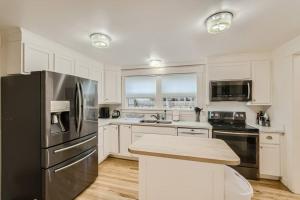 a kitchen with white cabinets and a stainless steel refrigerator at Prime Location walk to attractions w Free Parking in Seattle