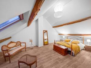 a bedroom with a bed and a chair in a attic at Villa Charme de Morin 15 min de Disneyland in Villiers-sur-Morin