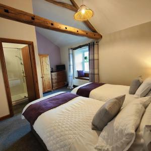 a bedroom with two beds and a large window at The Herdwick Inn in Penruddock