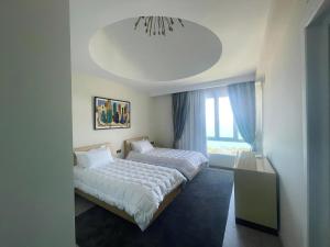 a bedroom with two beds and a chandelier at Triplex luxueux en front de mer. in La Marsa