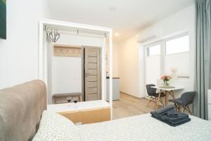 a bedroom with a bed and a desk and a table at Central Station Apartment No5 in Kaunas