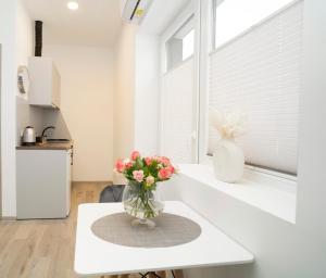 a vase of flowers sitting on a table in a kitchen at Central Station Apartment No5 in Kaunas