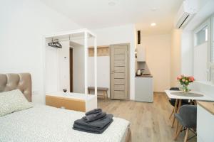 a bedroom with a bed and a table and a kitchen at Central Station Apartment No5 in Kaunas