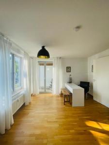 a living room with a desk and windows at Fly Inn Apartment Berlin in Schönefeld