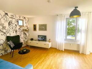 a living room with a couch and a tv and a window at Fly Inn Apartment Berlin in Schönefeld