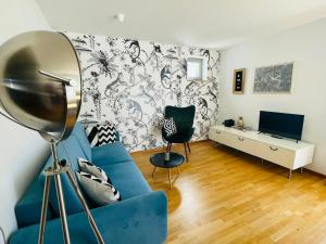 un soggiorno con divano blu e TV di Fly Inn Apartment Berlin a Schönefeld
