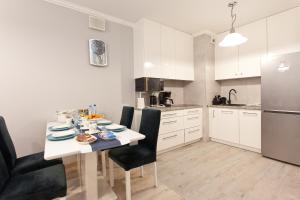 a kitchen with a table and chairs in a room at Apartament Kasprowicza 20 A z garażen in Kołobrzeg