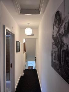 a hallway with a staircase with a large painting on the wall at Westend Villas in Leicester