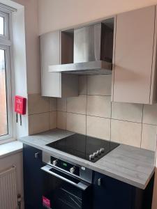 a kitchen with a stove top oven next to a window at Westend Villas in Leicester