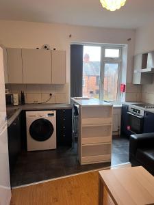 a kitchen with a washer and dryer in it at Westend Villas in Leicester