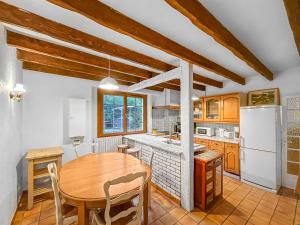 a kitchen with a table and a white refrigerator at Villa Charme de Morin 15 min de Disneyland in Villiers-sur-Morin