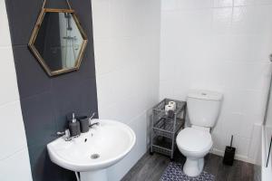 a bathroom with a white toilet and a sink at Stylish and Spacious 3-Bed House in Barrow-in-Furness with Free WiFi by Amazing Spaces Relocations Ltd in Barrow in Furness