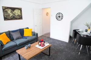 a living room with a blue couch and a table at Stylish and Spacious 3-Bed House in Barrow-in-Furness with Free WiFi by Amazing Spaces Relocations Ltd in Barrow in Furness