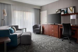 a living room with a couch and a flat screen tv at Courtyard by Marriott Mahwah in Mahwah