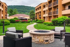 einen Innenhof mit Stühlen und einer Feuerstelle vor einem Gebäude in der Unterkunft Courtyard by Marriott Mahwah in Mahwah