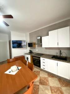 a kitchen with a wooden table and white cabinets at Casa Cruz de Marbella Luque in Luque