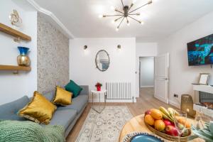 a living room with a couch and a bowl of fruit on a table at NIRU Experience Urban Escape 1BR Retreat in London