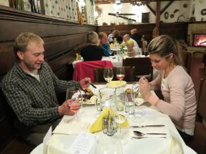 un homme et une femme assis à une table dans un restaurant dans l'établissement Horský pension Gendorf, à Černý Důl