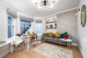 een woonkamer met een bank en een tafel bij NIRU Experience Urban Escape 1BR Retreat in Londen