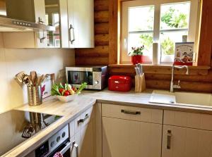 a kitchen with a counter top with a stove and a window at villa kunterBUNT in Grödersby