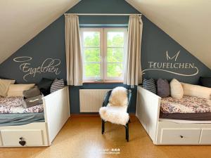 pokój dla chłopców z 2 łóżkami i krzesłem w obiekcie villa kunterBUNT w mieście Grödersby