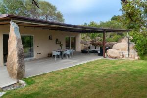 un patio cubierto con mesa y sillas en Villa Muxì, en Tortolì