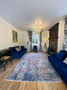 sala de estar con sofás azules y alfombra en Brittany Carantec Morlaix, en Saint-Martin-des-Champs
