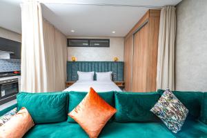 Maarif Elite Suites في الدار البيضاء: غرفة معيشة مع أريكة خضراء وسرير