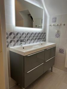 a bathroom with a sink and a mirror at Maison du Lavoir Disneyland in Bailly-Romainvilliers +16 photos