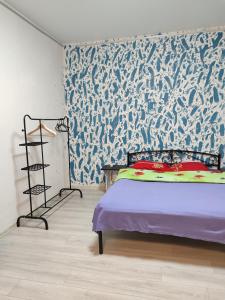 a bedroom with a bed with a blue and white wallpaper at Квартира целиком Киев Подол метро Контрактовая площадь in Kyiv