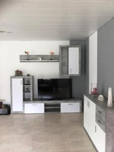 een grote woonkamer met een televisie en een keuken bij NEU! Ferienwohnung Kippblick Schiffweiler in Schiffweiler