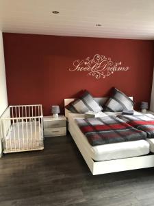 een slaapkamer met 2 bedden en een rode muur bij NEU! Ferienwohnung Kippblick Schiffweiler in Schiffweiler