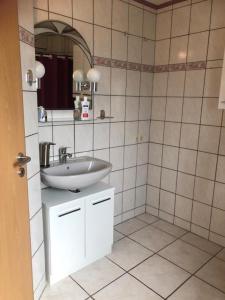 een badkamer met een wastafel en een spiegel bij NEU! Ferienwohnung Kippblick Schiffweiler in Schiffweiler