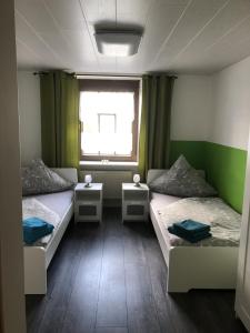 een kamer met 2 bedden en een raam bij NEU! Ferienwohnung Kippblick Schiffweiler in Schiffweiler