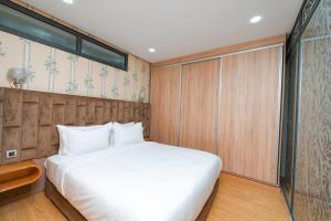 1 dormitorio con cama blanca y pared de madera en Maarif Elite Suites, en Casablanca