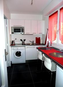 a kitchen with white cabinets and a sink and a dishwasher at Appartement Monplaisir Part Dieu in Lyon
