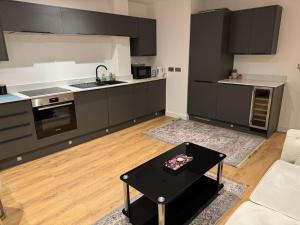 KentにあるElegant 3 Bed Flat in Ramsgateのキッチン(黒いテーブル付)が備わるリビングルームです。