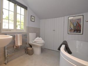 a bathroom with a tub and a toilet and a sink at 3 Bed in Bothenhampton DC160 in Bridport