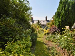 a path through a garden with a house in the background at 3 Bed in Bothenhampton DC160 in Bridport