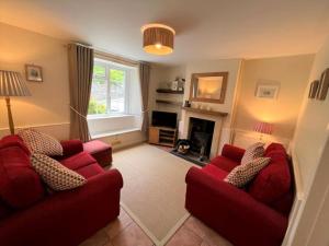 uma sala de estar com dois sofás vermelhos e uma lareira em 3 Bed in Osmington DC053 em Osmington